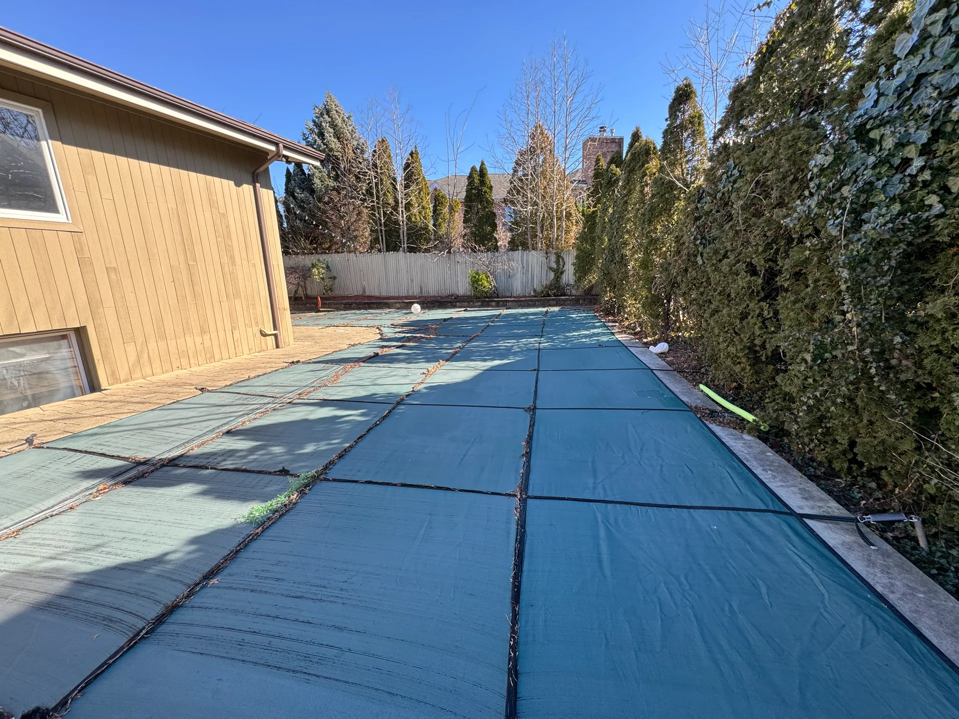 Backyard pool under a winter cover before renovation