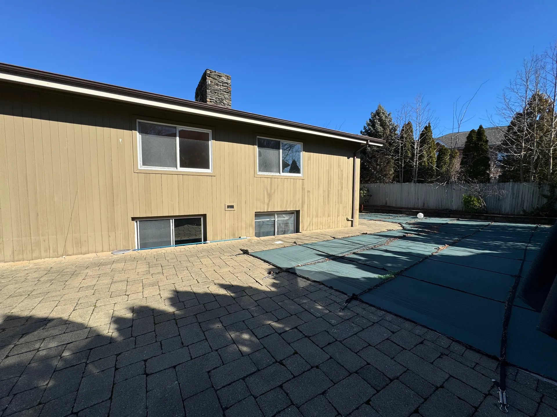 Rear exterior with covered pool and aging siding before renovation