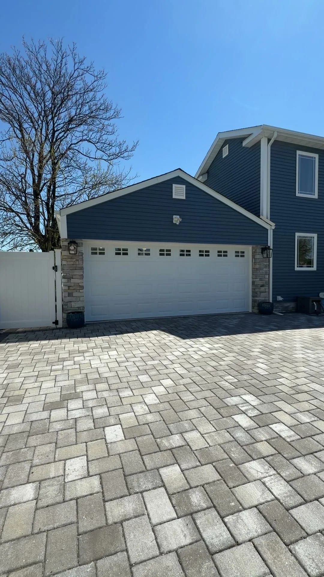 Custom garage — Elmwood Park, NJ — finished exterior with new carriage door, stone columns, and lanterns