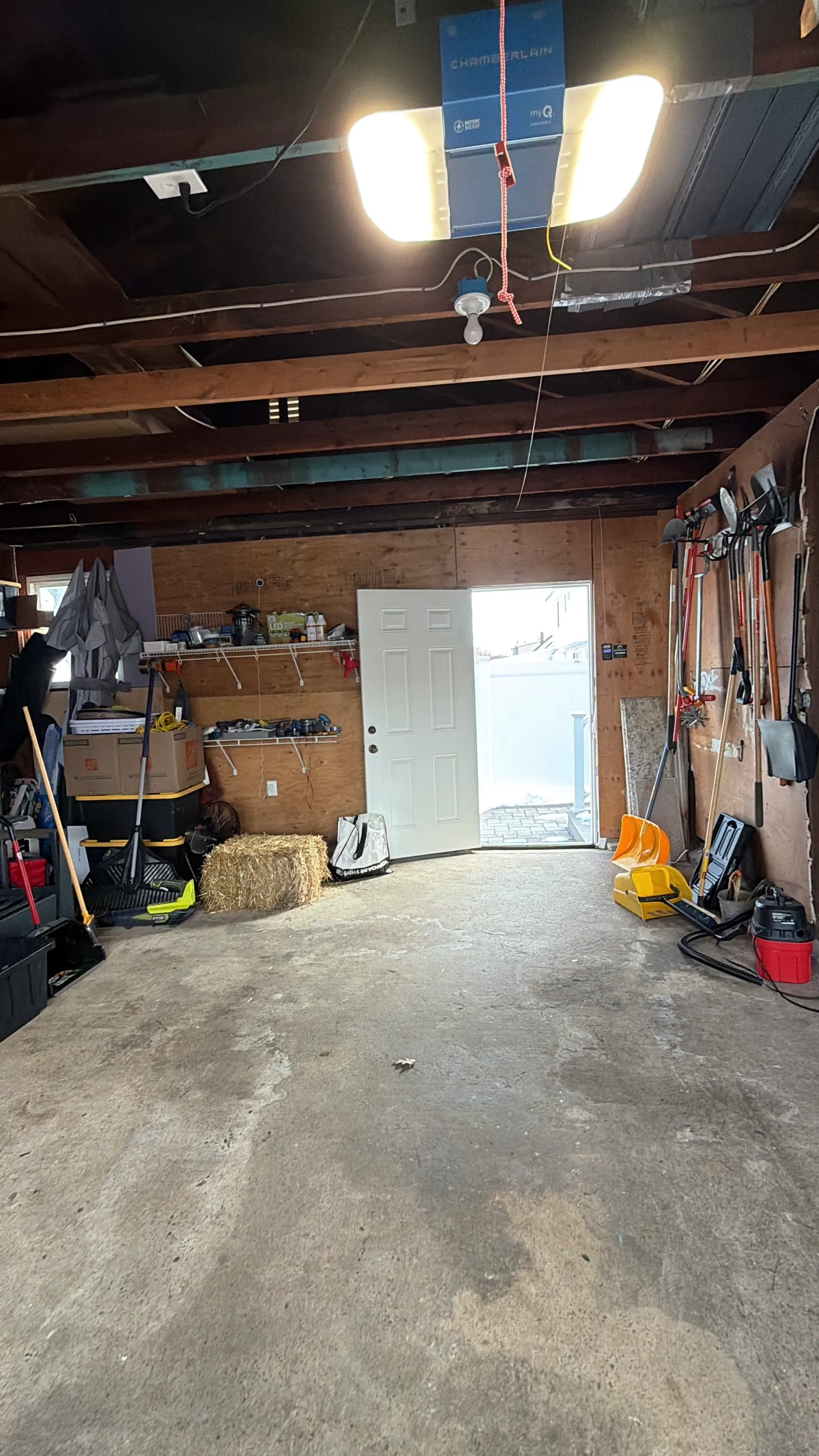 Original garage interior before renovation — exposed joists and clutter