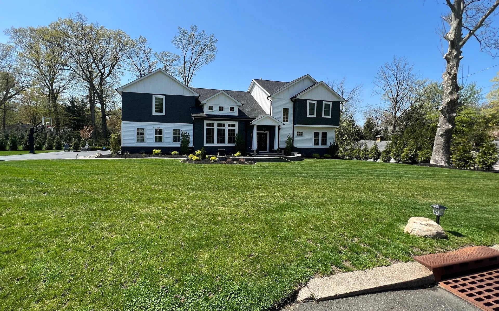 Finished custom home — front elevation with matured landscaping and lush lawn