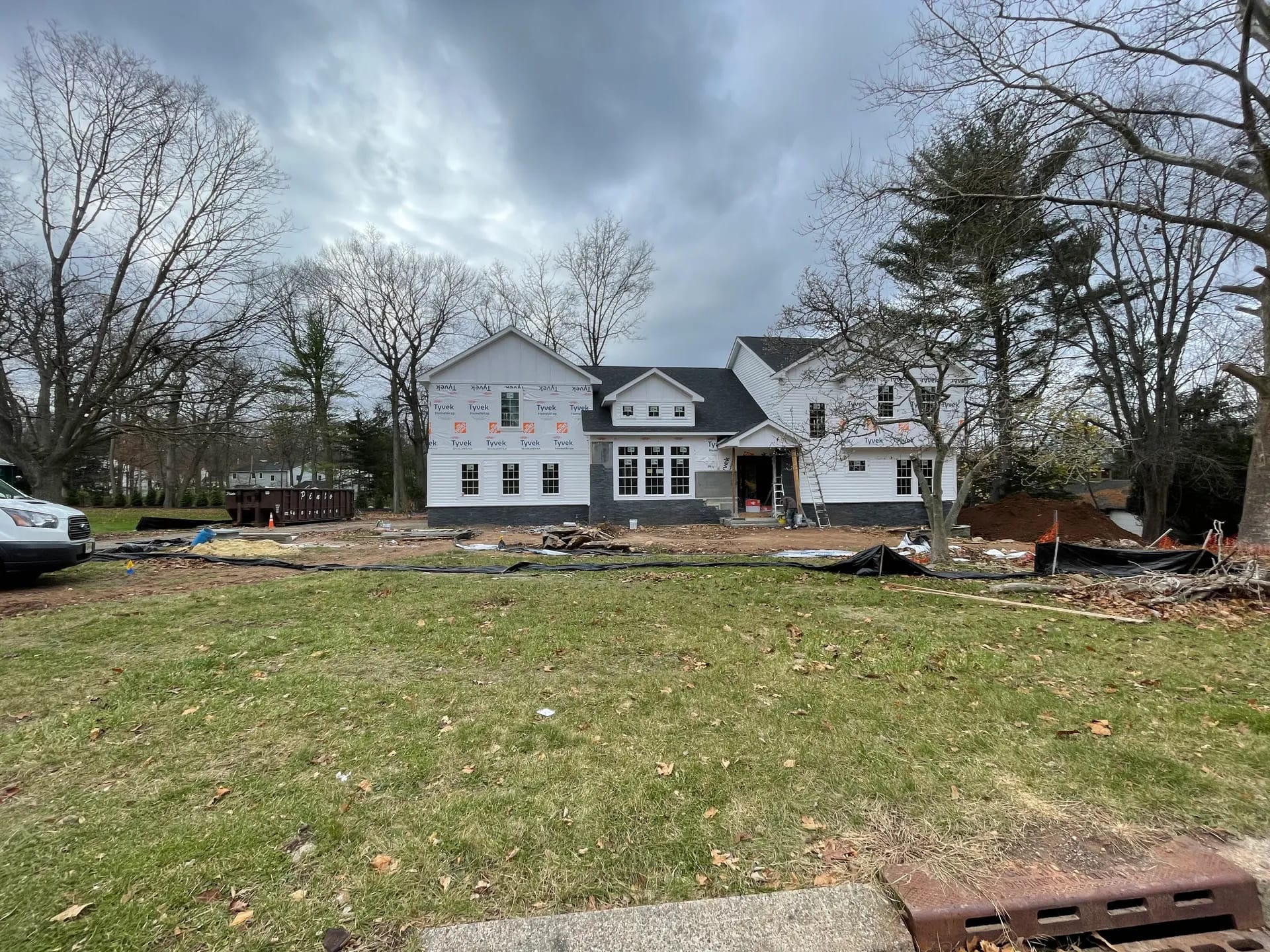 New custom home mid-construction — front elevation in house wrap