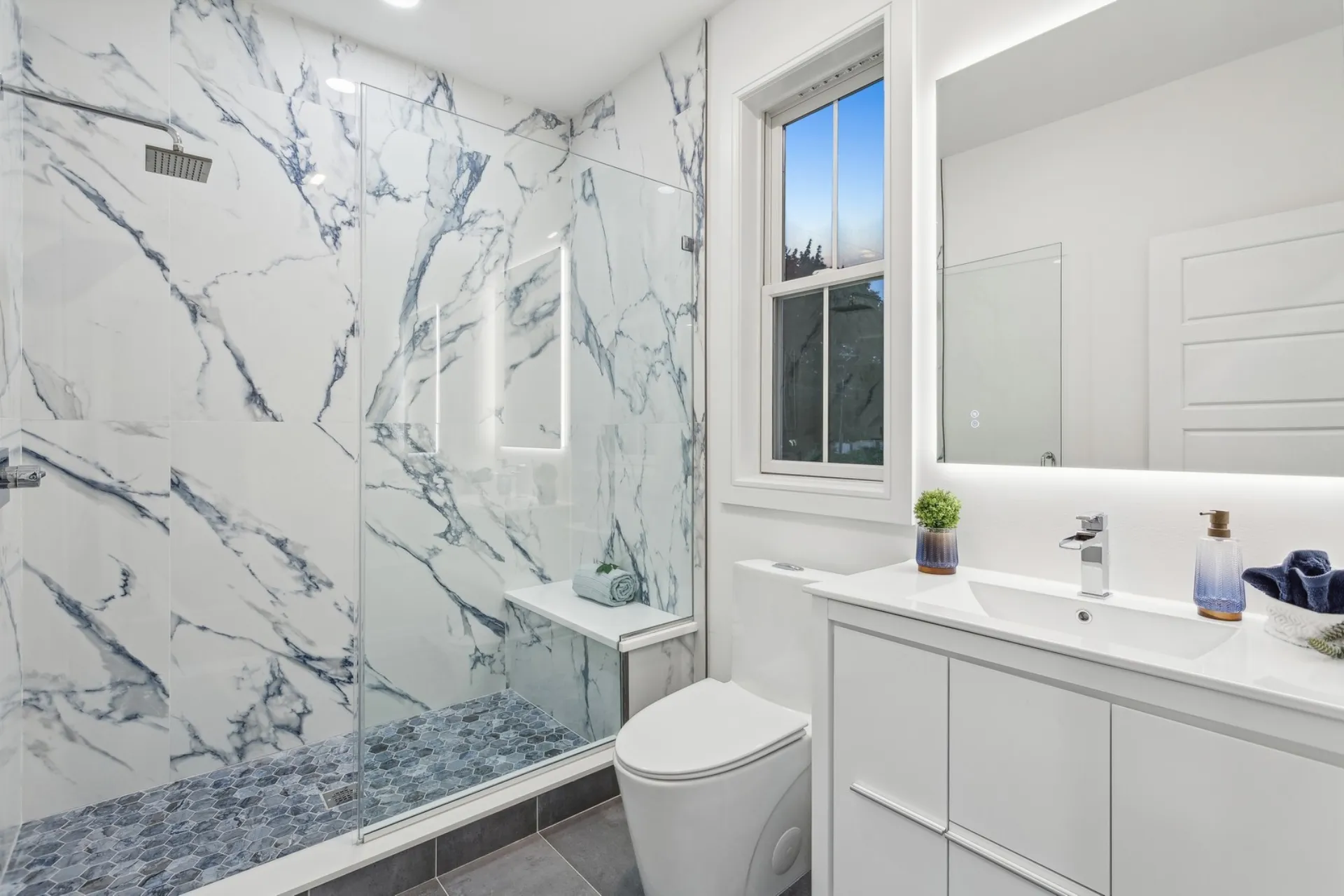 Primary bath with marble walk-in shower and backlit mirror — Woodcliff Lake, NJ