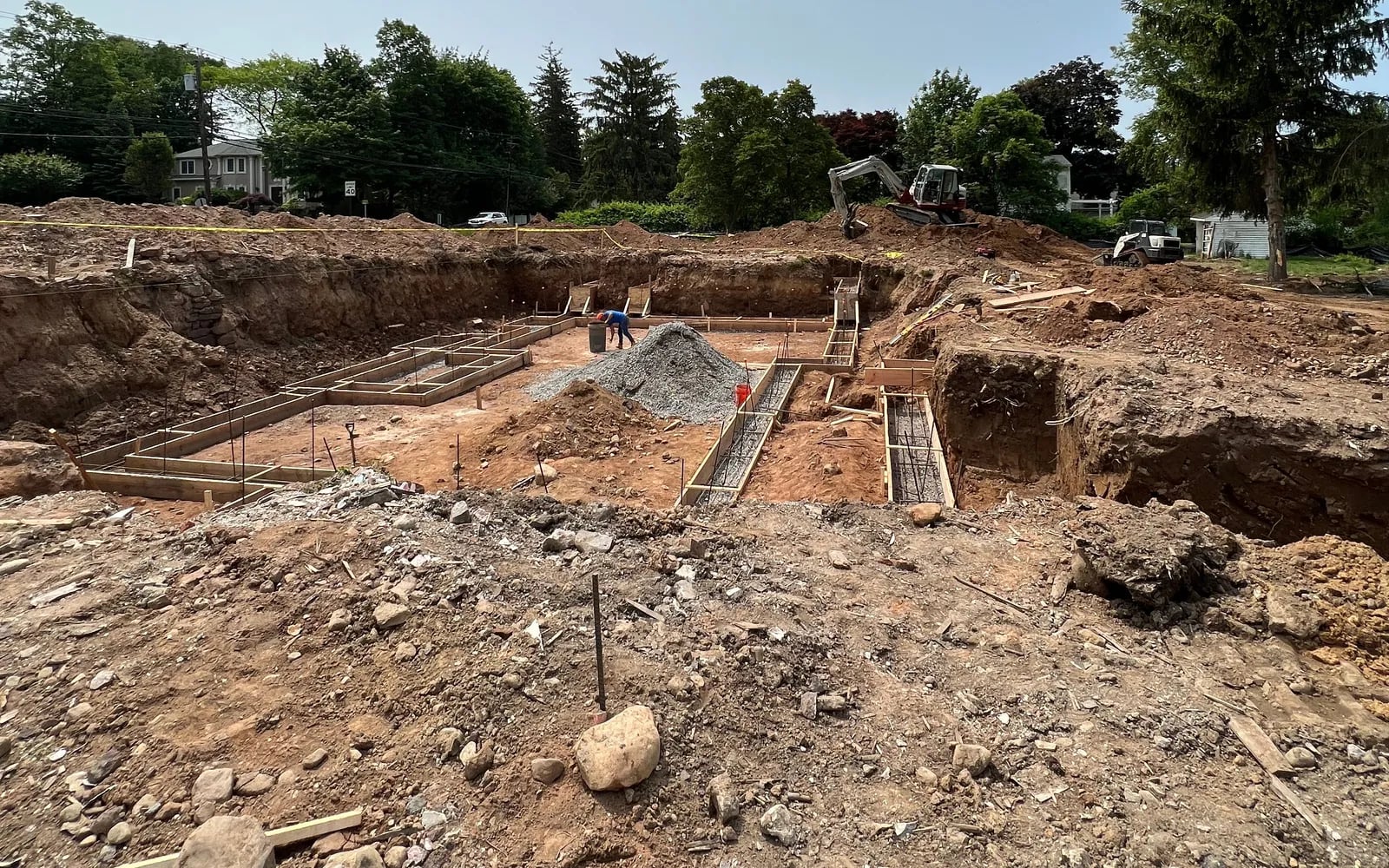 Excavation and poured footings on the cleared lot before construction